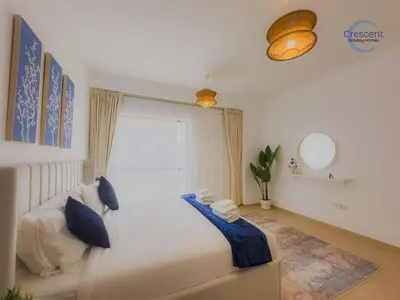 a bedroom with a large white bed with blue pillows at Relaxing Beach Escape in JBR in Dubai