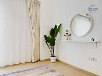 a white room with a mirror and a plant at Relaxing Beach Escape in JBR in Dubai