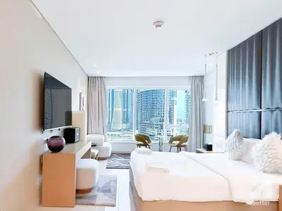 a bedroom with a large white bed and a large window at Luxury Studio in Business Bay with Canal View in Dubai