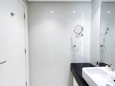 a white bathroom with a sink and a mirror at Luxury Studio in Business Bay with Canal View in Dubai