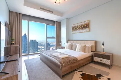 a bedroom with a large bed and a large window at Near Dubai Mall - Pool Access - Sun Set View - KingBed in Dubai