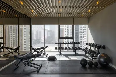 a gym with exercise equipment in a large building at Near Dubai Mall - Pool Access - Sun Set View - KingBed in Dubai