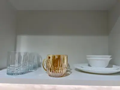 a table with plates and a gold cup on it at Studios Apartment in Azizi Riviera in Dubai