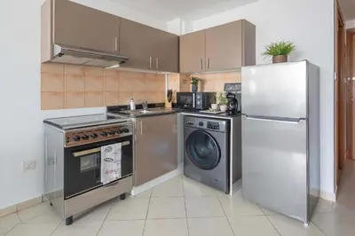 a kitchen with a washing machine and a refrigerator at Frank Porter - Lago Vista in Dubai
