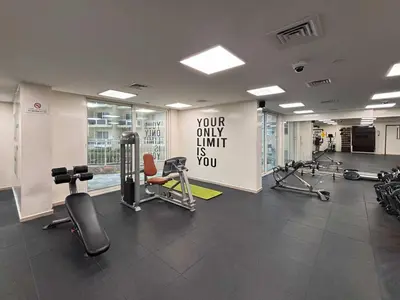 a gym with cardio equipment and a sign on the wall at Frank Porter - Lago Vista in Dubai