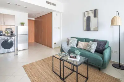 a living room with a green couch and a table at Frank Porter - Lago Vista in Dubai