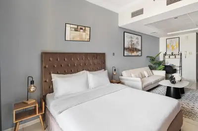 a bedroom with a large white bed and a couch at Stylish JLT Studio Lakeview Metro 5min & Marin in Dubai