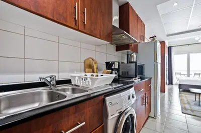 a kitchen with a sink and a dishwasher at Stylish JLT Studio Lakeview Metro 5min & Marin in Dubai