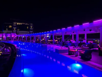 a swimming pool at night with purple lighting at Palm Jumeirah Beachfront apartment with Amazing Infinity Pool and private beach in Dubai