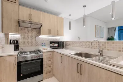 a kitchen with a stove and a sink at Palm Jumeirah Beachfront apartment with Amazing Infinity Pool and private beach in Dubai