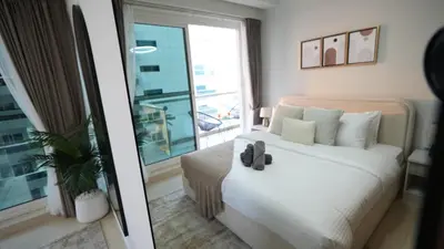 a bedroom with a white bed and a large window at 1BHK full canal view apartment in Business bay ! in Dubai