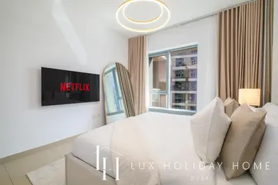 a white bedroom with a bed and a window at LUX The Burj Khalifa Fountain View Suite 2 in Dubai