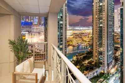 a balcony with a view of a city at night at LUX The Burj Khalifa Fountain View Suite 2 in Dubai