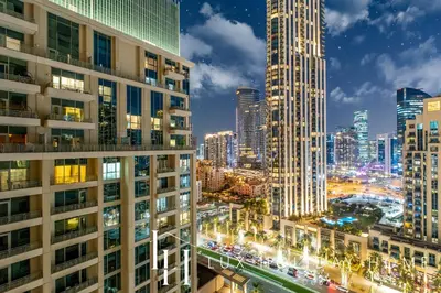 a view of a city skyline at night at LUX The Burj Khalifa Fountain View Suite 2 in Dubai