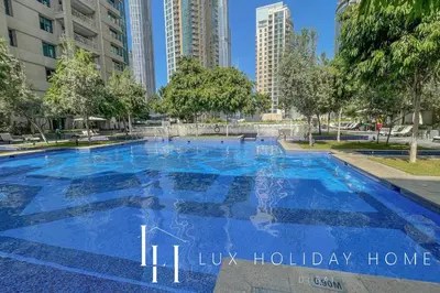 a large blue swimming pool in a city at LUX The Burj Khalifa Fountain View Suite 2 in Dubai