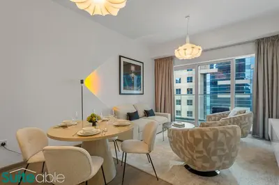 a dining room and living room with a table and chairs at Exquisite 1 Bedroom Sea View with Lavish Amenities in Dubai