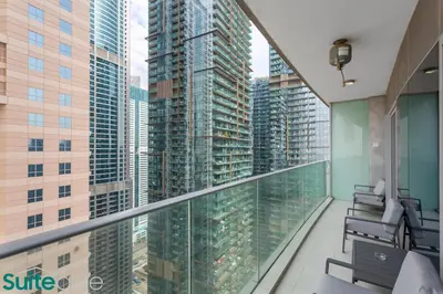 a balcony with two chairs and a view of a city at Exquisite 1 Bedroom Sea View with Lavish Amenities in Dubai