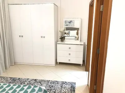 a bedroom with a white dresser and a mirror at Cozy one bedroom close to beach and metro station in Dubai