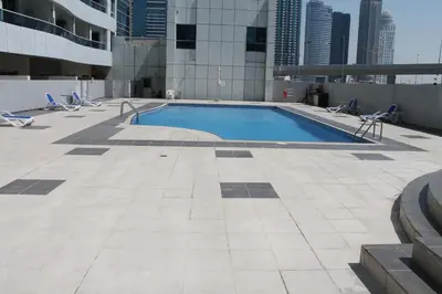 a swimming pool on the roof of a building at Cozy one bedroom close to beach and metro station in Dubai