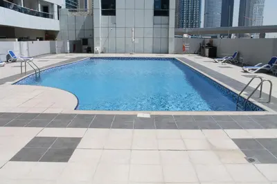 a swimming pool on the roof of a building at Cozy one bedroom close to beach and metro station in Dubai