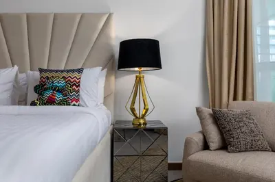 a bedroom with a bed and a lamp and a chair at Missoni Luxury Life Suite DPA Direct Pool Access in Dubai