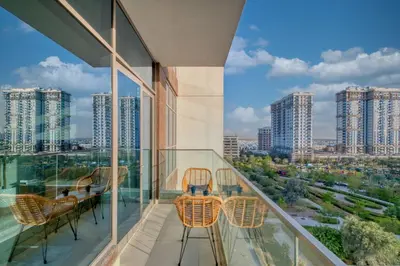 a balcony with chairs and a view of a city at Sleek and Modern Stay in Dubai Hills in Dubai