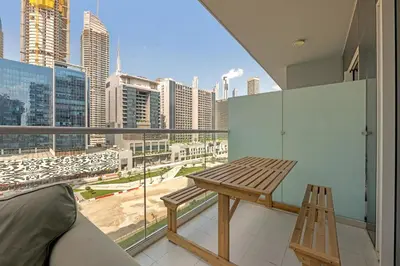 a balcony with a wooden bench and a view of a city at City View 1BR Prime Location in Business Bay by Vibel in Dubai