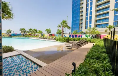 a swimming pool with lounge chairs and a building at Dubai Aykon city in Dubai