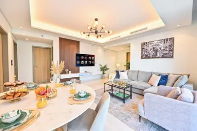 a living room with a table and a couch at New Luxury SeaView 2Bed - Spectacular Rooftop Infinity Pool, Bar & Burj Views! in Dubai