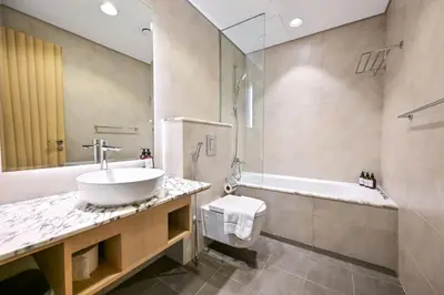 a bathroom with a sink and a bath tub at New Luxury SeaView 2Bed - Spectacular Rooftop Infinity Pool, Bar & Burj Views! in Dubai