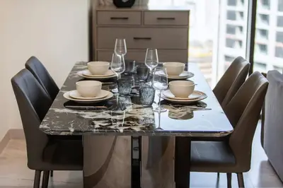 a dining room table with glasses and plates on it at High-Rise 1BR Apartment with Burj Khalifa view in Dubai
