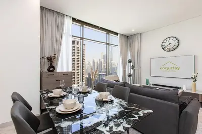 a living room with a table and a large window at High-Rise 1BR Apartment with Burj Khalifa view in Dubai