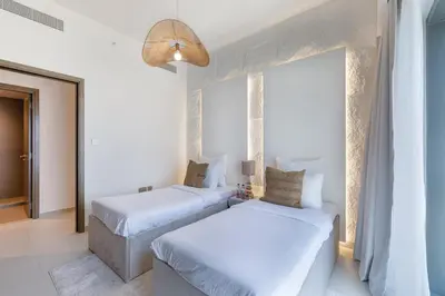 two beds in a white room with a window at ALiving Elite 3BR Apartment I Burj Khalifa & Fountain View I Burj Royale in Dubai