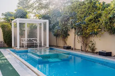 a swimming pool with a white shutter next to a building at Stunning 4BR Jumeira Park Villa With Pool and Jacuzzi in Dubai