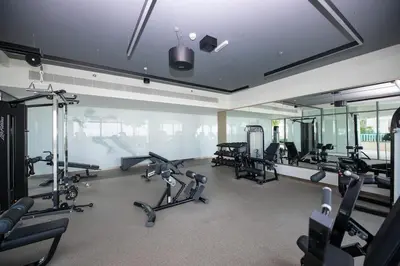 a gym with several treadmills and exercise bikes at Luxury 2BR Apt with Pool, Gym & Sea Views in Dubai