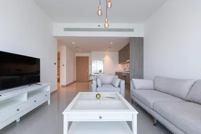a living room with a couch and a tv at Luxury 2BR Apt with Pool, Gym & Sea Views in Dubai