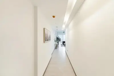 a hallway with white walls and a white floor at FAM Living - 3 bedroom and Maids Room Retreat Overlooking Dubai Canal in Dubai