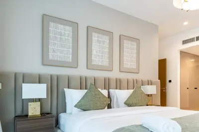 a bedroom with a large white bed with two lamps at FAM Living - 3 bedroom and Maids Room Retreat Overlooking Dubai Canal in Dubai