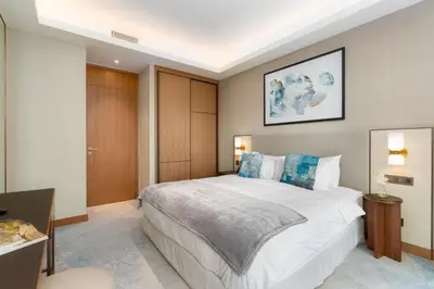 a bedroom with a large white bed with blue pillows at Ultimate Stay Luxurious Address Opera 2BR Next to Burj Khalifa and Dubai Mall Large Balcony with Stunning Views in Dubai