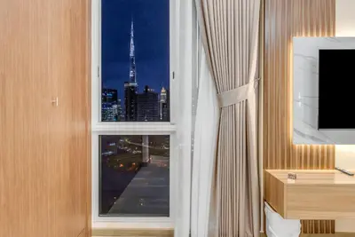 a room with a window with a view of a city at Burj Khalifa & Canal Views at Mayfair Tower in business bay - Luxurious 1BDR Apartment in Dubai