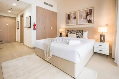 a bedroom with a large white bed and a bathroom at Community View Studio with Balcony, Azizi Riviera 24, Al Merkadh by Deluxe Holiday Homes in Dubai