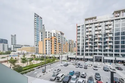 a parking lot in a city with tall buildings at Community View Studio with Balcony, Azizi Riviera 24, Al Merkadh by Deluxe Holiday Homes in Dubai