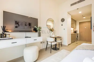 a white bedroom with a vanity and a mirror at Community View Studio with Balcony, Azizi Riviera 24, Al Merkadh by Deluxe Holiday Homes in Dubai
