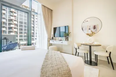 a bedroom with a bed and a table and a mirror at Community View Studio with Balcony, Azizi Riviera 24, Al Merkadh by Deluxe Holiday Homes in Dubai