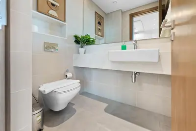 a bathroom with a white toilet and a sink at Magnificent - New 1BR in Canal Front Residences in Dubai