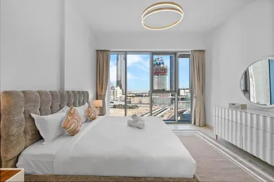 a bedroom with a bed and a large window at Magnificent - New 1BR in Canal Front Residences in Dubai