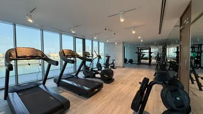 a gym with a bunch of exercise equipment in a building at Magnificent - New 1BR in Canal Front Residences in Dubai