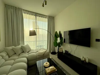 a living room with a white couch and a large window at Stylish 1br With Garden View In Jvc in Dubai