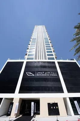 a tall building with a sign on the side of it at Stylish 1br With Garden View In Jvc in Dubai