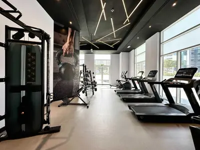 a gym with a bunch of treadmills and machines at Silkhaus Chic Studio at Barsha Heights in Madison in Dubai